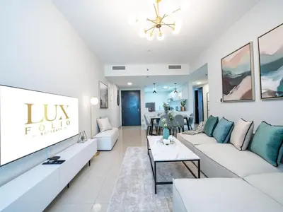 a living room with a couch and a table at Sleek 2 Bed in Sports City in Dubai