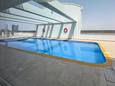 a swimming pool on the side of a building at Sleek 2 Bed in Sports City in Dubai