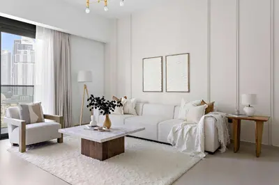 a white living room with a white couch and a table at Silkhaus Heart of Downtown 3 BDR with Maid Room in Dubai