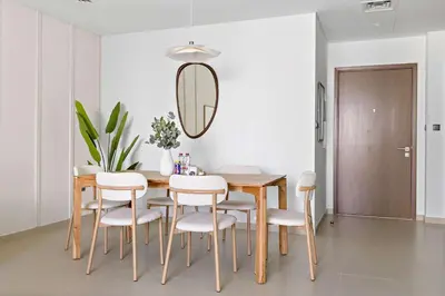 a dining room with a table and chairs and a mirror at Silkhaus Heart of Downtown 3 BDR with Maid Room in Dubai
