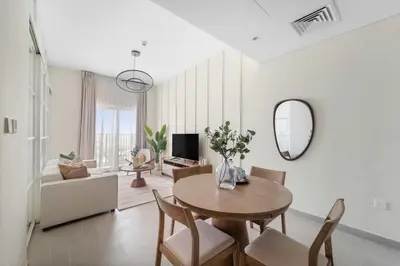 a living room with a table and chairs and a mirror at Silkhaus Next Golf Club Golfville in Dubai Hills in Dubai