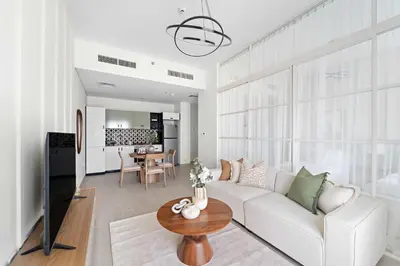 a living room with a white couch and a table at Silkhaus Next Golf Club Golfville in Dubai Hills in Dubai