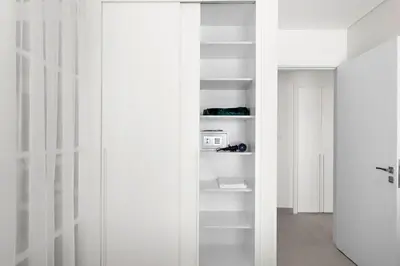 a white closet with white shelves in a room at Silkhaus Next Golf Club Golfville in Dubai Hills in Dubai