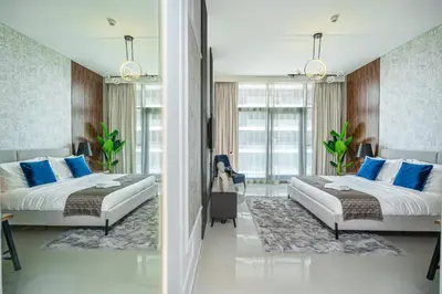 two beds in a bedroom with blue pillows at Escape24 Premium Studio in Damac Hills in Dubai