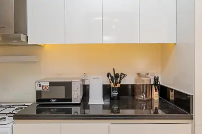 a kitchen with a counter top with a microwave at Escape24 Premium Studio in Damac Hills in Dubai
