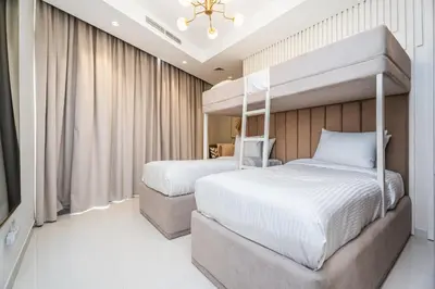 a bedroom with two beds and a chandelier at Escape24 Spacious 2BR Infinity Pool with Burj Views in Dubai