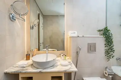 a bathroom with a sink and a mirror at Escape24 Spacious 2BR Infinity Pool with Burj Views in Dubai