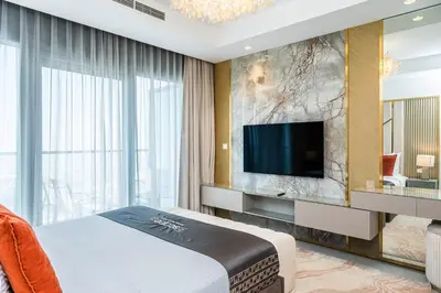 a bedroom with a bed and a tv on a wall at Escape24 Spacious 2BR Infinity Pool with Burj Views in Dubai