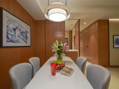 a dining room with a table with a vase of flowers at Venetian - The Address Residences Dubai Opera Full Burj & Fountain Views in Dubai