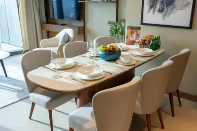 a dining room table with chairs and a bowl of fruit on it at Luxury Suite at Address Residences Dubai Opera , High-Floor Ocean Views, Burj Khalifa Pool Access, Steps from Dubai Mall in Dubai