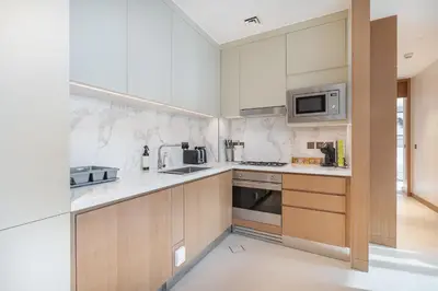 a kitchen with white counters and a microwave at Luxury Suite at Address Residences Dubai Opera , High-Floor Ocean Views, Burj Khalifa Pool Access, Steps from Dubai Mall in Dubai