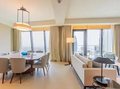 a living room with a couch and a table and chairs at Luxury 3BR Apartment at Address Opera in Dubai