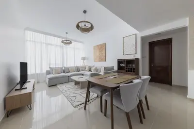 a living room with a couch and a table and chairs at Stylish 2 bd Apt in Business Bay, Prime Location in Dubai