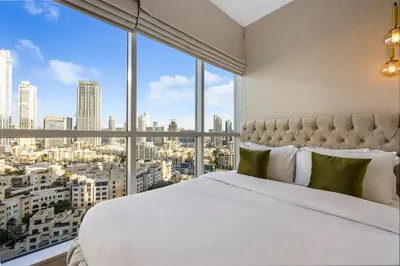 a bed in a room with a large window at Durrani Homes - Grand 03 in Dubai