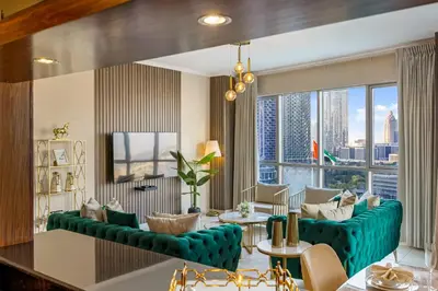 a living room with a green couch and a large window at Durrani Homes - Grand 03 in Dubai