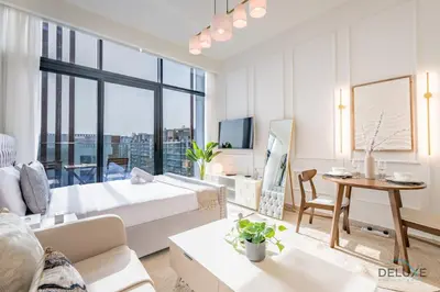 a living room with a bed and a table at Spacious Studio with Community and Partial Burj Khalifa Views by Deluxe Holiday Homes in Dubai