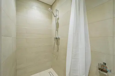 a bathroom with a shower with a shower curtain at Spacious Studio with Community and Partial Burj Khalifa Views by Deluxe Holiday Homes in Dubai