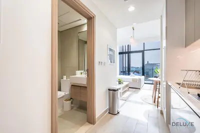 a bathroom with two sinks and a tub and a toilet at Spacious Studio with Community and Partial Burj Khalifa Views by Deluxe Holiday Homes in Dubai