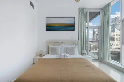 a bedroom with a large bed with a large window at ShoresInn - Dreamy Marina Views in Dubai in Dubai