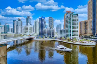 a boat in a river in a city with tall buildings at ShoresInn - Dreamy Marina Views in Dubai in Dubai