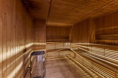 a empty wooden sauna with a trash can in it at Stylish 1BR in JVC with Pool & Nearby Parks in Dubai