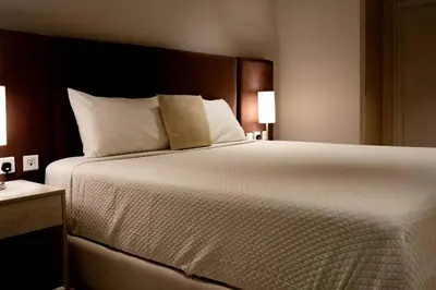 a bedroom with a large white bed with two lamps at Palm Jumeirah Seven Palm 1 Bedroom with infinity pool and Palm jumeirah beach in Dubai