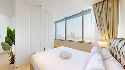 a bedroom with a white bed and a large window at Sky Gardens - Cosy Studio in DIFC in Dubai
