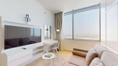 a living room with a large television and a couch at Sky Gardens - Cosy Studio in DIFC in Dubai