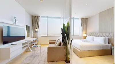 a bedroom with a bed and a couch and a tv at Sky Gardens - Cosy Studio in DIFC in Dubai