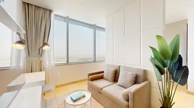 a living room with a couch and a chair at Sky Gardens - Cosy Studio in DIFC in Dubai