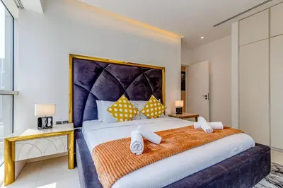 a bedroom with a large bed with towels on it at Sleek and Modern 2BR in West Avenue, Dubai Marina- Allsopp&Allsopp in Dubai