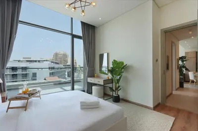 a bedroom with a large white bed and a large window at Livbnb - Stay at Signature Livings Penthouse, JVC in Dubai