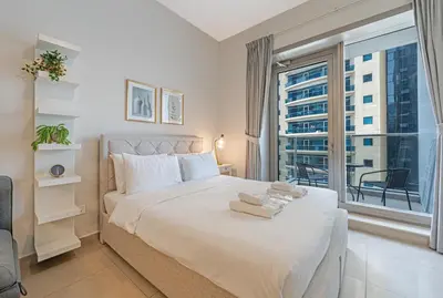 a bedroom with a large bed with a large window at Walk to JBR Beach I Marina Studio Stay I Wi-fi in Dubai