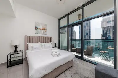 a bedroom with a white bed and a large window at Stylish 1BR Apartment at DAMAC Merano Tower with Great View in Dubai