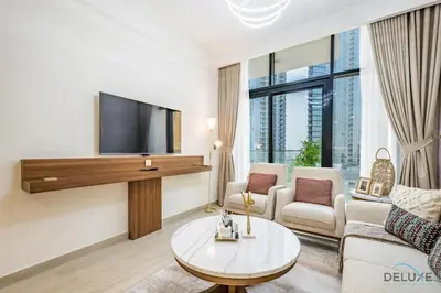 a living room with a tv and a couch and a table at Inviting 2BR Apartment in Azizi Riviera 39, Al Merkadh by Deluxe Holiday Homes in Dubai