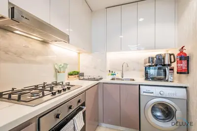a kitchen with a stove and a washing machine at Inviting 2BR Apartment in Azizi Riviera 39, Al Merkadh by Deluxe Holiday Homes in Dubai