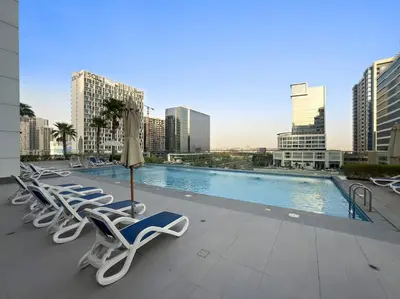 a row of lounge chairs and a pool in a city at Chic Studio Near Burj Khalifa, Dubai Opera & Dubai Mall with City Skyline Views in Dubai