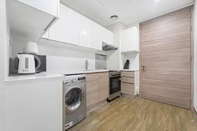 a kitchen with a washing machine and a washer at Chic Studio Near Burj Khalifa, Dubai Opera & Dubai Mall with City Skyline Views in Dubai