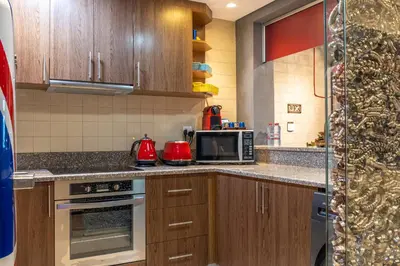 a kitchen with wooden cabinets and a microwave at Paradise of the Mind by Lagom in Dubai