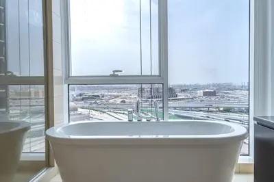 a bath tub in a bathroom with a large window at Paradise of the Mind by Lagom in Dubai