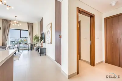 a living room with a kitchen and a dining room at Captivating 1BR Apartment in Zazen Gardens, Al Furjan by Deluxe Holiday Homes in Dubai
