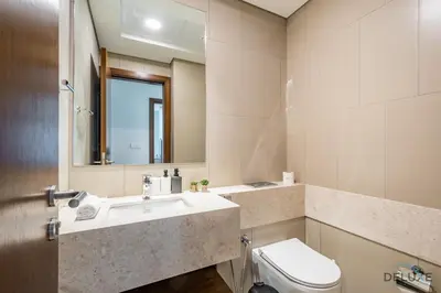 a bathroom with a sink and a toilet and a mirror at Captivating 1BR Apartment in Zazen Gardens, Al Furjan by Deluxe Holiday Homes in Dubai