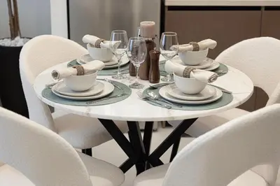 a white table with plates and cups and wine glasses at Burj Crown - Urban Chic Opera Boulevard View, Walk to Dubai Mall in Dubai