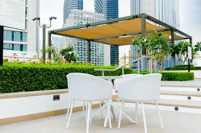 a table and white chairs on a balcony with buildings at Burj Crown - Urban Chic Opera Boulevard View, Walk to Dubai Mall in Dubai