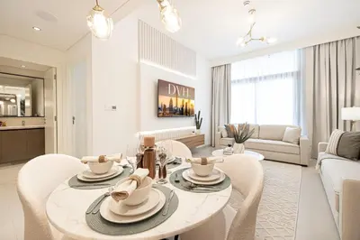 a white living room with a table and chairs at Burj Crown - Urban Chic Opera Boulevard View, Walk to Dubai Mall in Dubai