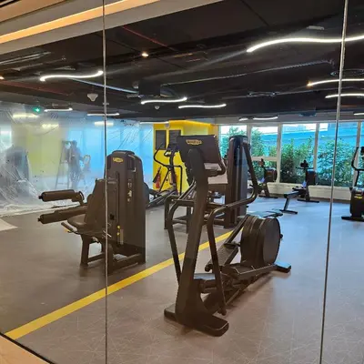 a gym with cardio equipment and a glass wall at Spacious Studio MeDoRe Tower in Dubai