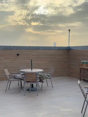 a patio with a table and chairs on a roof at Bright Spacious Apartment in Dubai Sports City in Dubai