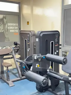 a gym with several tread machines and a chair at Bright Spacious Apartment in Dubai Sports City in Dubai