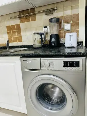 a washing machine in a kitchen with a counter at Bright Spacious Apartment in Dubai Sports City in Dubai