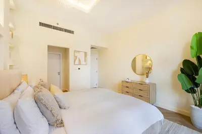 a bedroom with a white bed and a mirror at Daniels 2BR at Rimal JBR with Marina View in Dubai